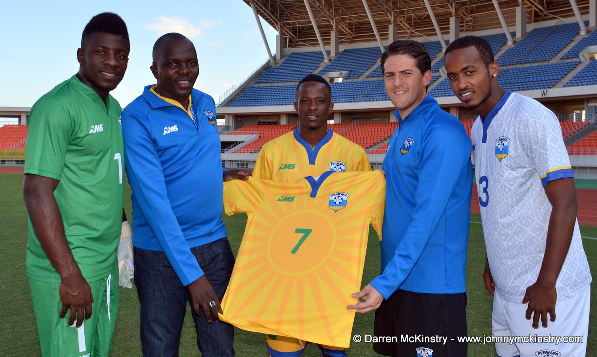 L-R: Olivier Kwizera (Goalkeeper);  Jean-Olivier Mulindahabi (General Secretary, FERWAFA); Haruna Niyonzima (Captain); Coach McKinstry; Yannick Mukunzi  with the new Rwanda Amavubi Home Shirt by AMS  [Players are modelling new goalkeeping; home and away kits by AMS.  Pictured at Training camp ahead of Rwanda Amavubi v Mozambique, 13 June 2015  (Pic © Darren McKinstry / www.johnnymckinstry.com)]